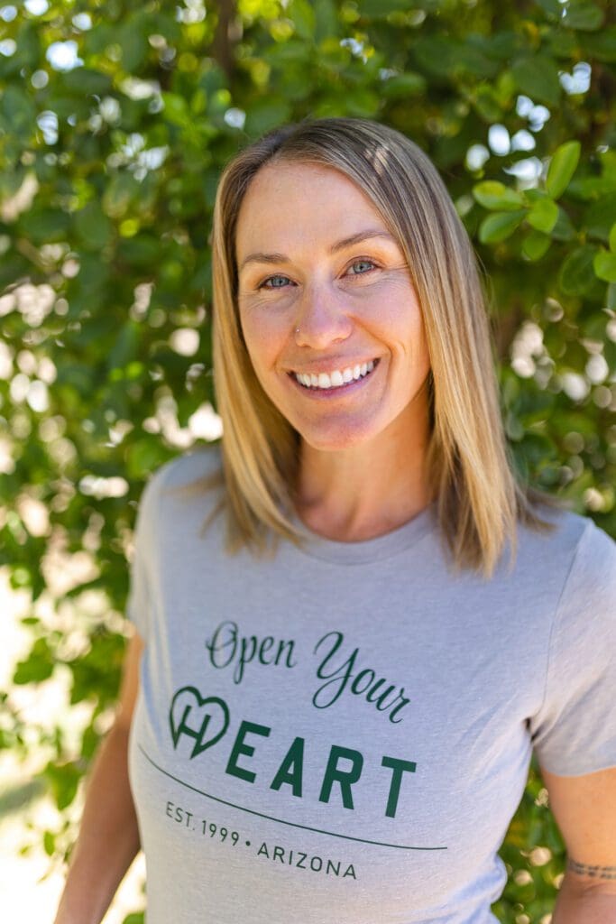 Smiling woman wearing "Open Your Heart" t-shirt